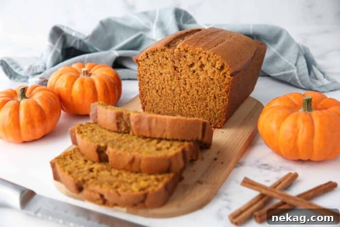 A beautiful, moist pumpkin loaf, superior to Starbucks, presented on a wooden cutting board with several slices ready to be eaten.