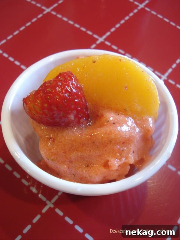 Sun-Kissed Strawberry Peach Sorbet 3 Close-up of freshly churned Strawberry Peach Sorbet with a scoop and fruit