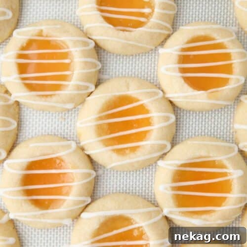 Shortbread cookies with lemon curd in the center and a powdered sugar glaze drizzled on top.