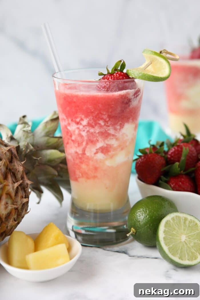 Vibrant Virgin Miami Vice Refresher 6 Virgin Miami Vice Drink, a layered non-alcoholic beverage with piña colada and strawberry daiquiri, garnished with strawberry and lime in a tall glass.