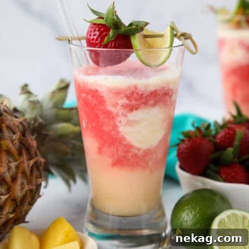 Virgin Miami Vice Drink in a tall glass with a strawberry and lime garnish.