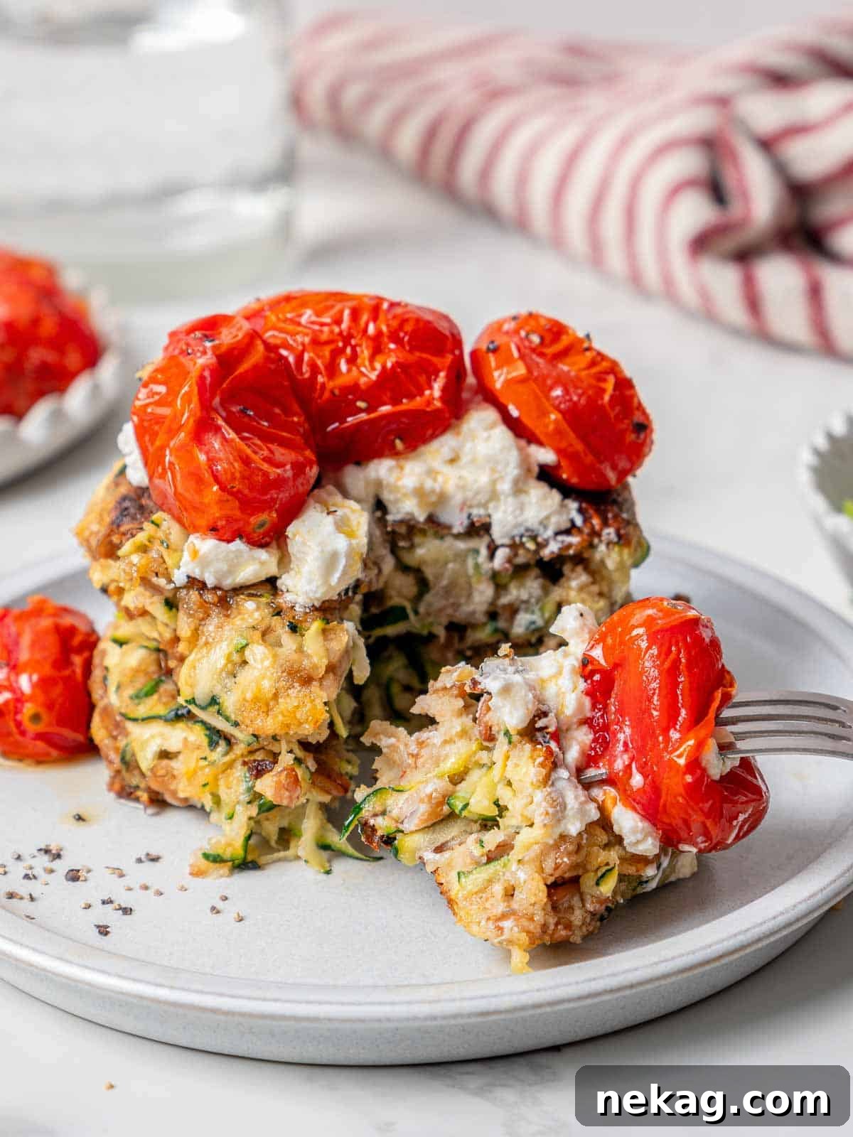 A delicious bite of zucchini fritter on a fork, showing its tender interior and crispy texture.