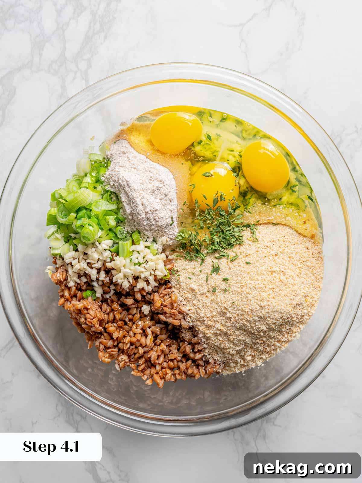 All the delicious ingredients for zucchini fritters, including farro and fresh herbs, in a bowl before mixing.