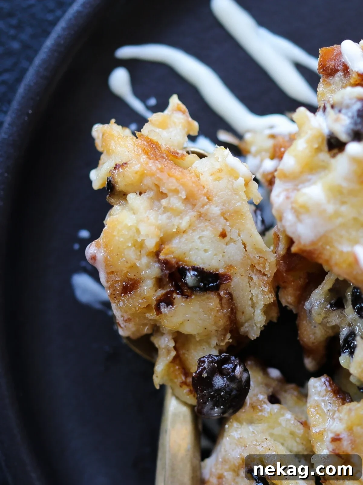 A close-up shot of a perfect bite of bread pudding on a fork, highlighting its moist and delicious texture.