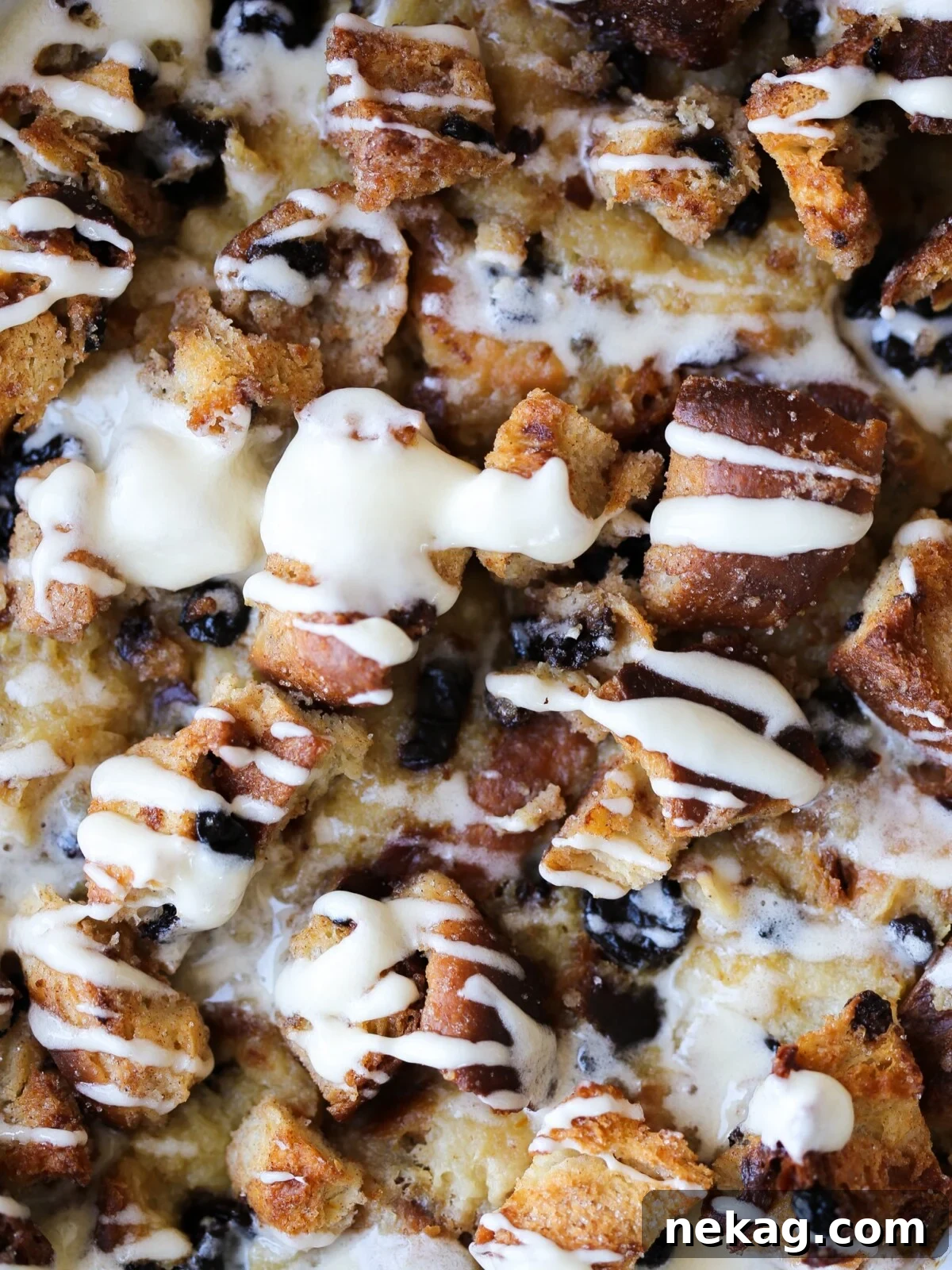 Warm bread pudding featuring a tempting crunchy sugared topping, generously drizzled with rich hard sauce, presented in a serving dish.