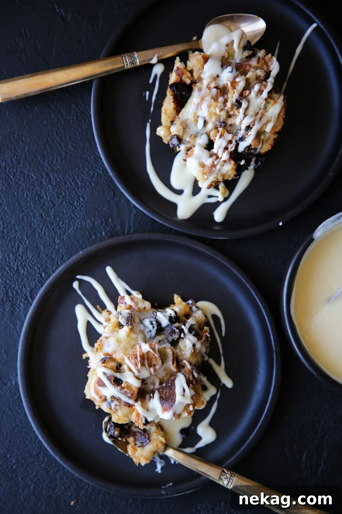 Beautifully arranged plates of bread pudding, each elegantly drizzled with hard sauce, prepared for serving at a festive gathering.