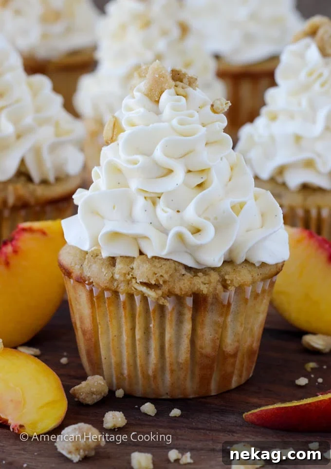 Perfectly frosted Peach Crisp Cupcakes ready to be enjoyed, topped with delicate Swiss meringue buttercream swirls