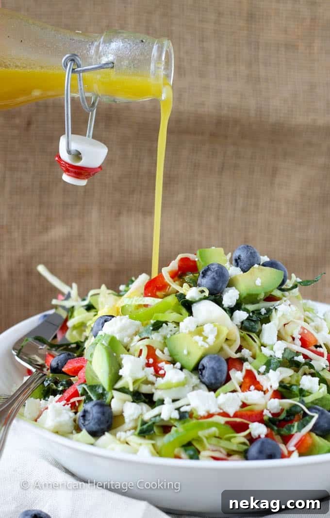 Close-up of a bowl of Healthy Kale and Cabbage Slaw Salad with avocado and blueberries