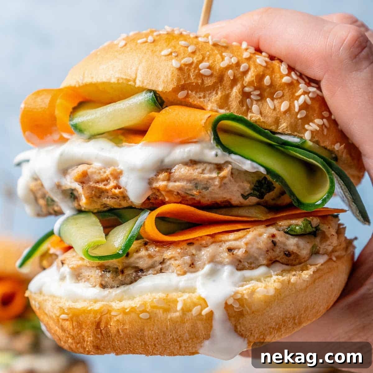 Ultimate Chicken Burgers 3 hand holding a perfectly cooked chicken burger on a bun.