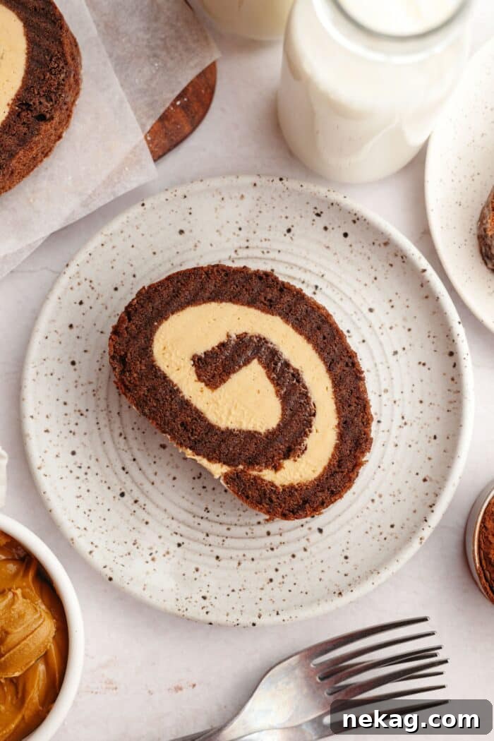 Velvet Chocolate Roulade 3 A slice of chocolate sponge roulade with peanut butter cake filling on a plate.