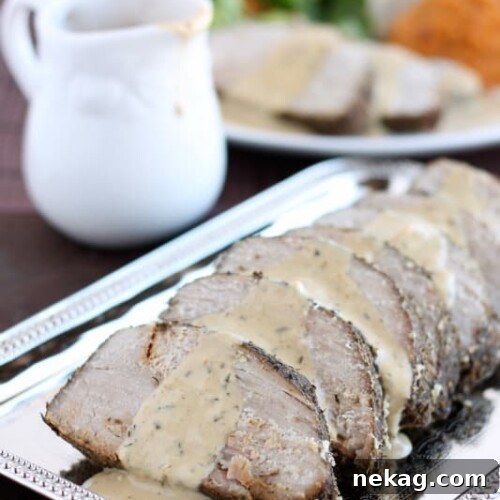 The full spread: savory pork roast, pan gravy, and sweet potato & apple mash on a rustic plate.