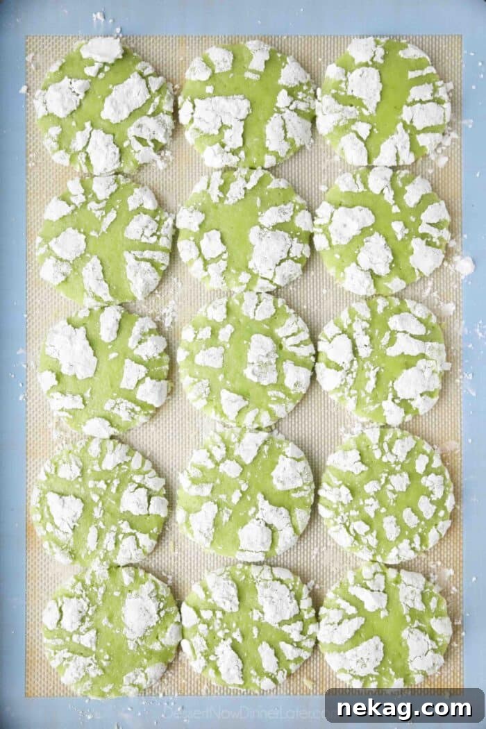 Tangy Lime Crinkle Clouds 4 Baked lime crinkle cookies on a sheet tray.