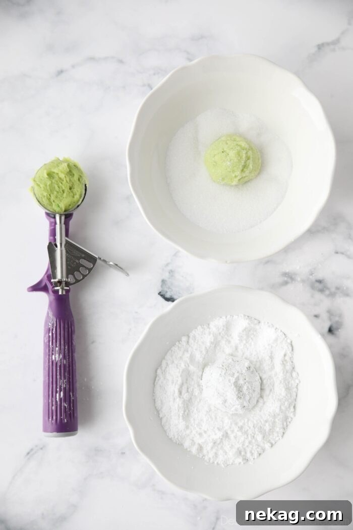 Tangy Lime Crinkle Clouds 6 Scoop of lime cookie dough being coated with granulated sugar, and then powdered sugar.