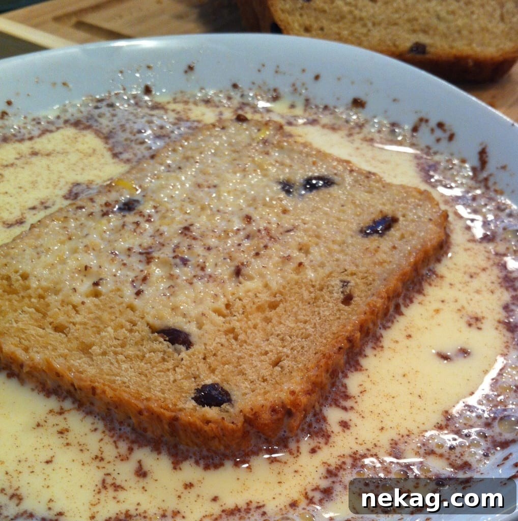 Two slices of golden Cinnamon Raisin French Toast on a plate, ready to be served.
