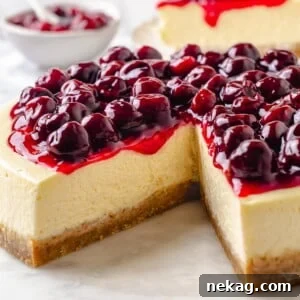 Homemade cherry topping gently drips down the side of a creamy cheesecake, resting on a golden brown crust, inviting a taste.