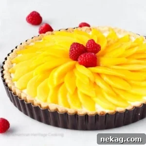 Coconut Mango Tart with a luscious sliced mango topping, an inviting tropical treat.