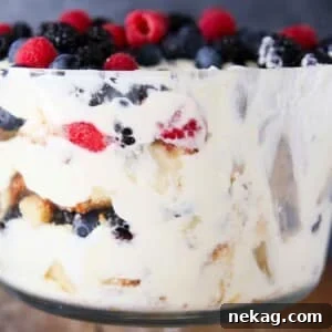 A side view of a vibrant berry trifle with lemon whipped cream, showcasing its beautiful layers.