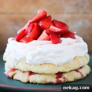 An Old Fashioned Strawberry Shortcake, unsliced and presented on a green plate, ready to be enjoyed.