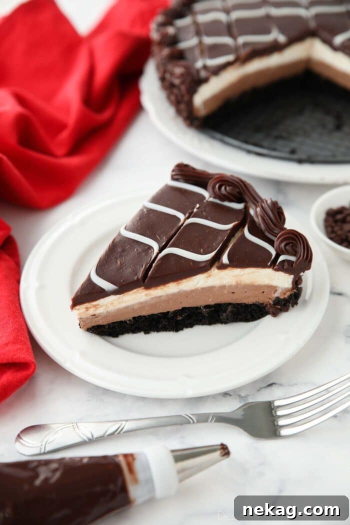 Slice of Olive Garden Black Tie Mousse Cake on a plate showing layers of chocolate cake, chocolate mousse, vanilla mousse, with swirled white and dark chocolate ganache on top.