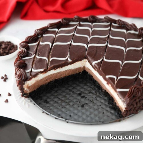 Copycat Olive Garden Black Tie Mousse Cake missing a couple of pieces to show layers of chocolate cake, chocolate mousse, vanilla mousse, with swirled white and dark chocolate ganache on top.