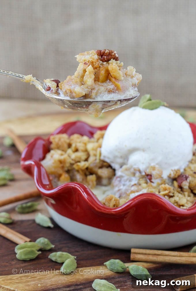 A beautifully baked Cardamom Pear Crisp in a small baking dish, topped with golden-brown oat crumble, ready to be served.