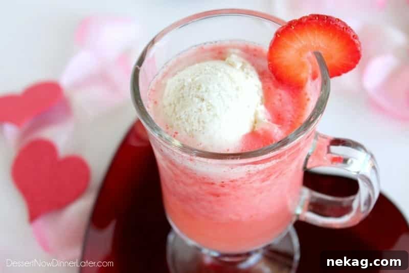 Two glasses of Sparkling Strawberry Float, showcasing the rich red strawberry puree and white ice cream, with fresh strawberries in the background.
