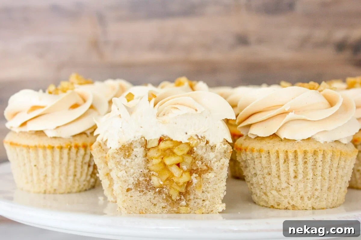 Luscious Caramel Apple Cupcakes 2 Cake stand full of caramel apple cupcakes, one sliced in half to show apple filling.