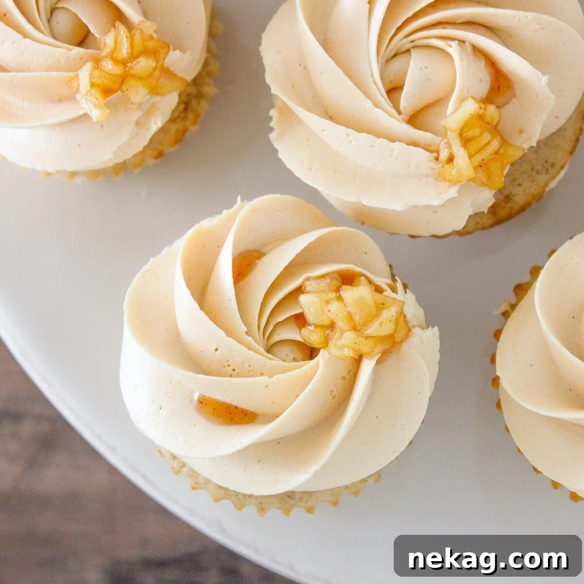Luscious Caramel Apple Cupcakes 4 Caramel Apple Cupcakes on marble cake stand.
