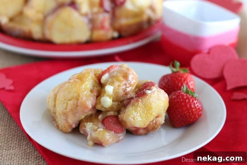Close-up of baked Vanilla Strawberry Monkey Bread showing the pull-apart texture, strawberries, and melted white chocolate
