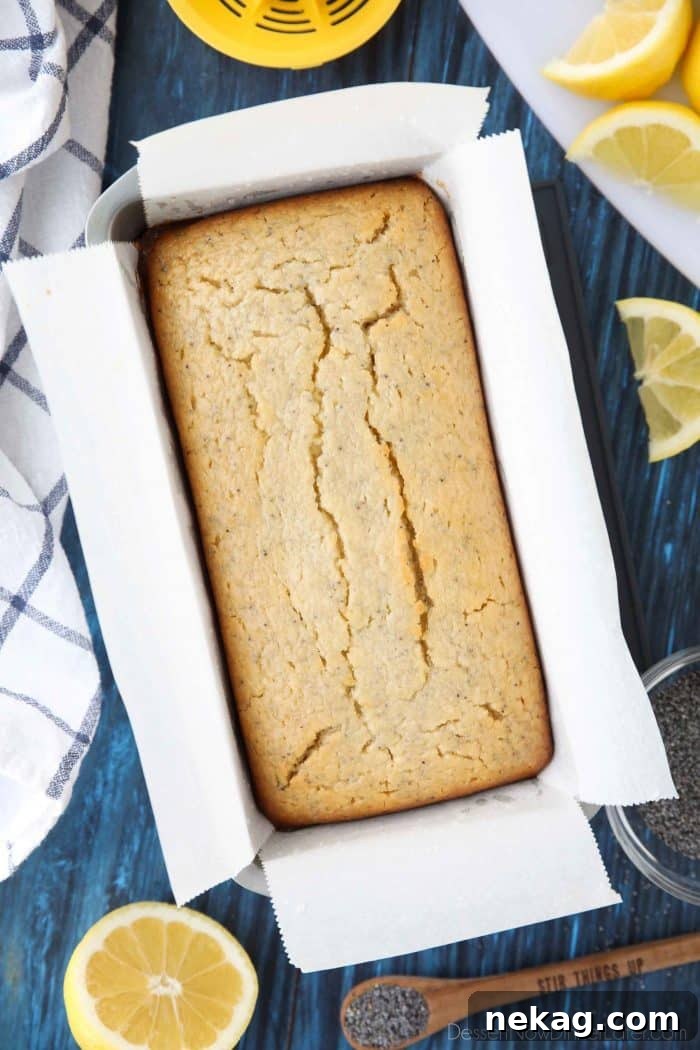 Zesty Lemon Poppy Seed Loaf 6 Lemon Poppy Seed Bread baking in a parchment-lined loaf pan.