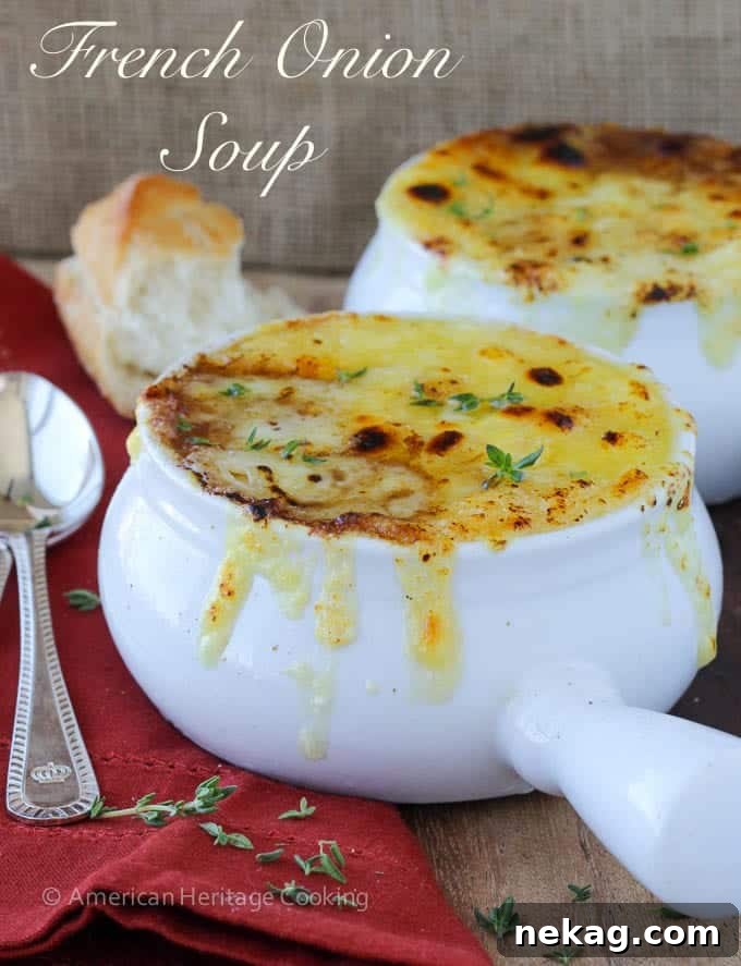 Quintessential French Onion Soup 14 French onion soup in a white bowl with little fresh thyme leaves on top.