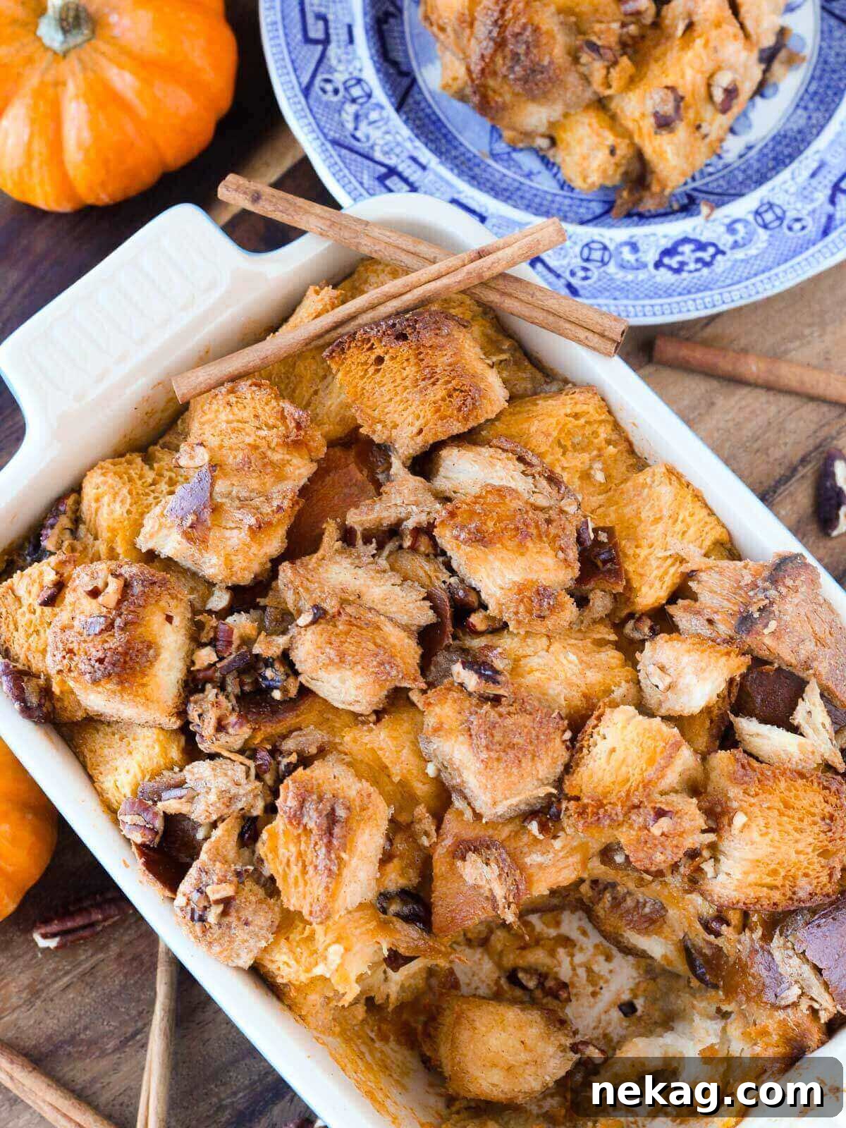 Warm pumpkin bread pudding in a blue baking dish, ready to be served.