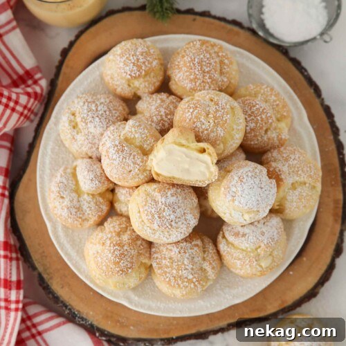 Holiday Eggnog Cream Puffs 15 Top view of eggnog cream puffs with one cut open in the center.