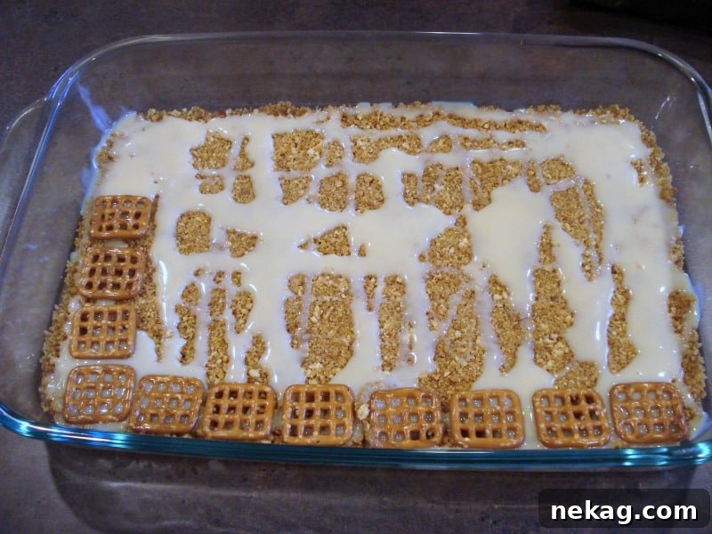 Caramel Pretzel Dream Bars 4 Ingredient layers being assembled for Caramel Pretzel Magic Bars