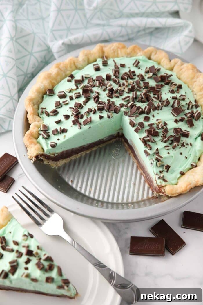 Decadent Chocolate Mint Dream 3 Chocolate mint pie in pan with layers of pastry crust, chocolate ganache, mint no bake cheesecake, and chopped Andes mints.