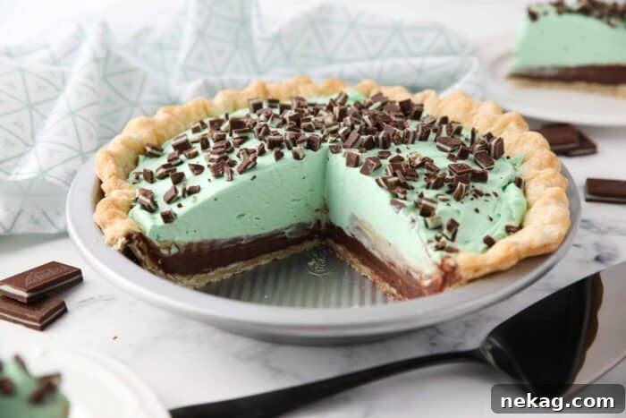 Decadent Chocolate Mint Dream 9 Chocolate mint pie in pan with layers of pastry crust, chocolate ganache, mint no bake cheesecake, and chopped Andes mints.