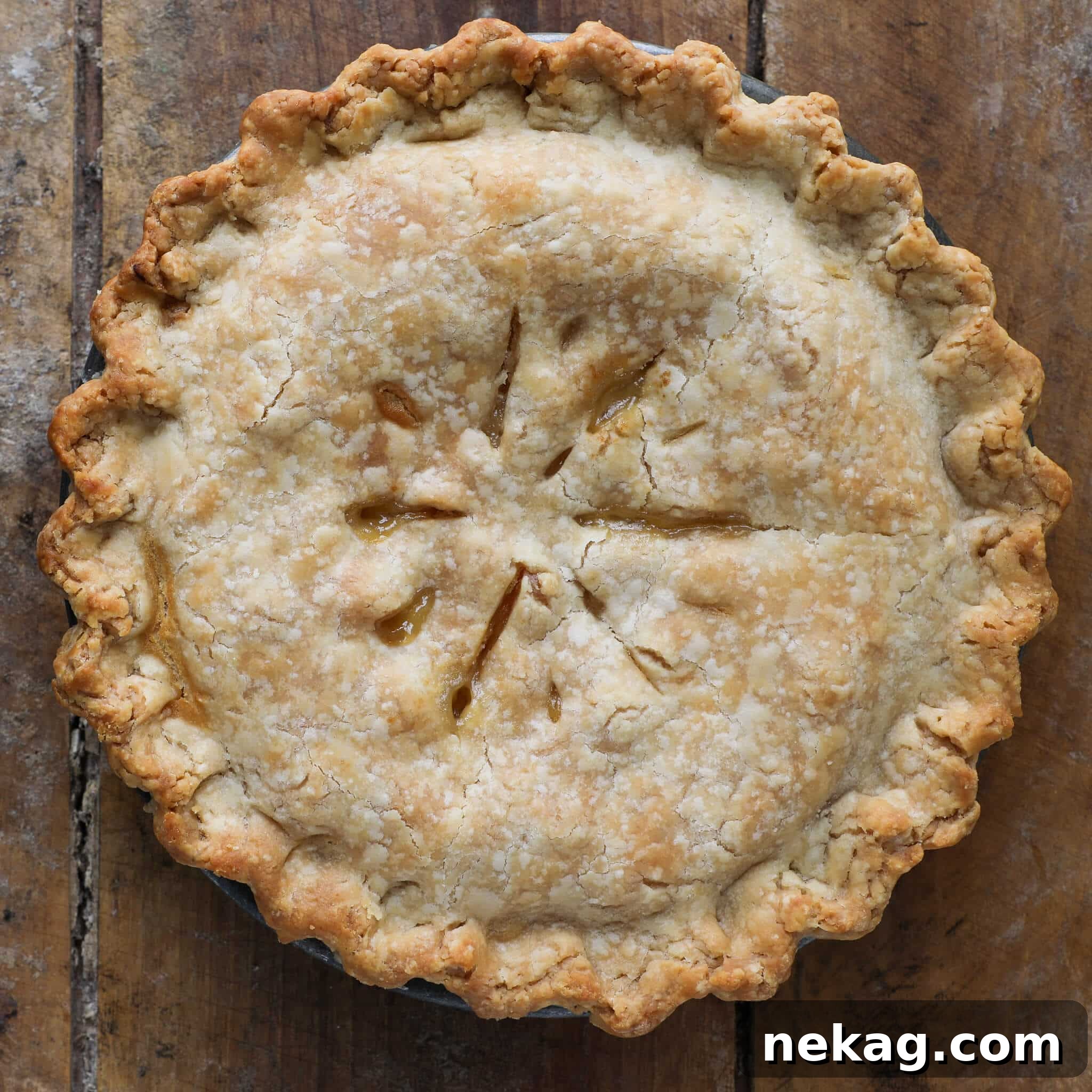 Flaky Crisco Pie Crust Recipe 12 A beautifully baked Old Fashioned Peach Pie, unsliced and resting on a wooden surface, showcasing a golden crust.