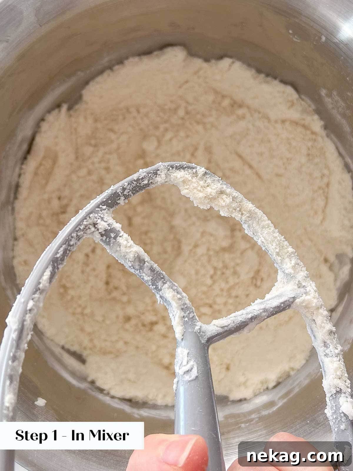 Flaky Crisco Pie Crust Recipe 7 Crisco shortening being cut into flour using a stand mixer with a paddle attachment, creating a crumbly texture.