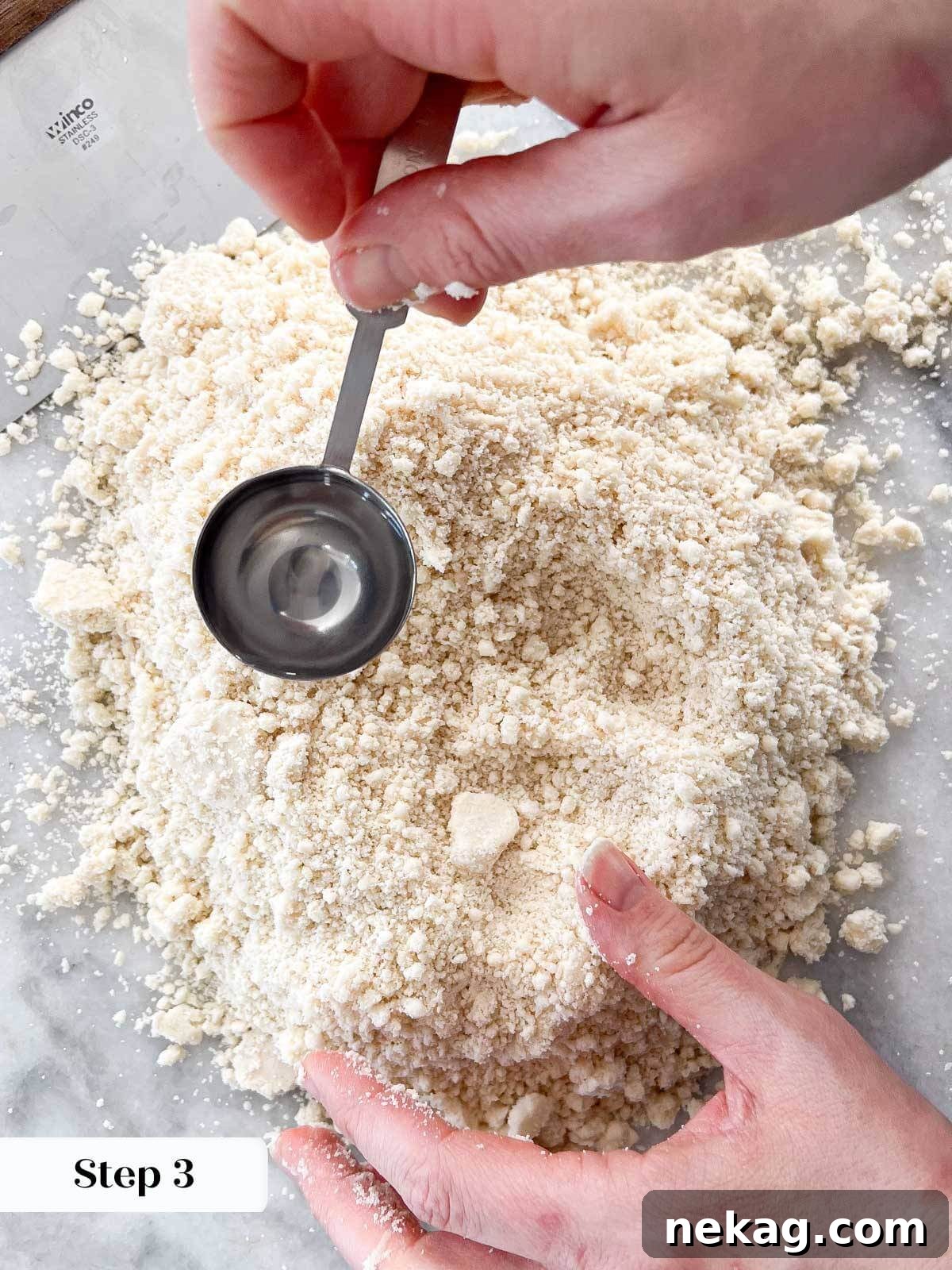 Flaky Crisco Pie Crust Recipe 8 Ice-cold water being added teaspoon by teaspoon to pie crust dough mixture.