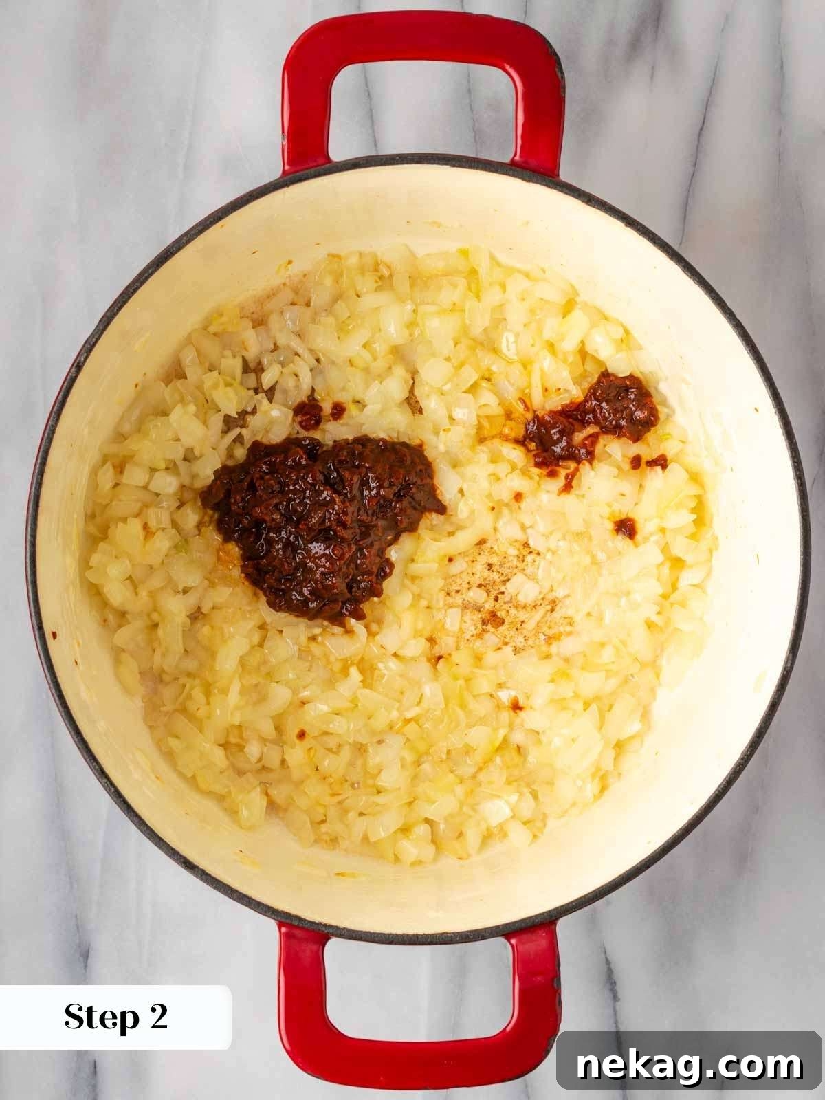 The savory blend of cooking onions, garlic, and chipotle chilies in adobo sauce in a deep pot.