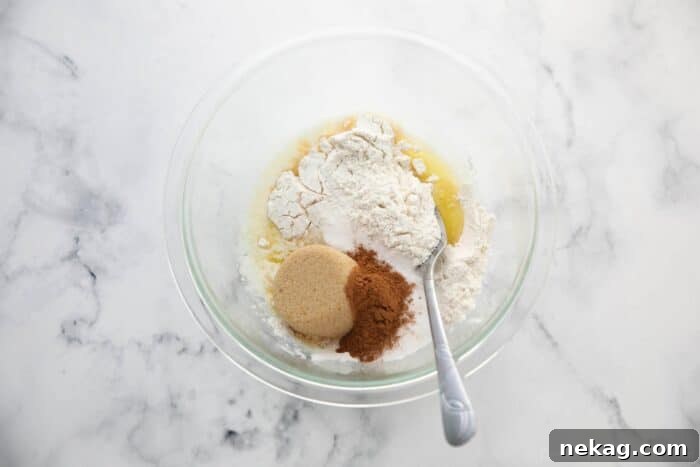 Ingredients for pumpkin spice streusel topping, including melted butter, flour, sugars, and spices, mixed in a bowl.