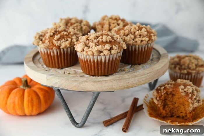 Freshly baked pumpkin streusel muffins with rich crumb topping, cooling on a wire rack.
