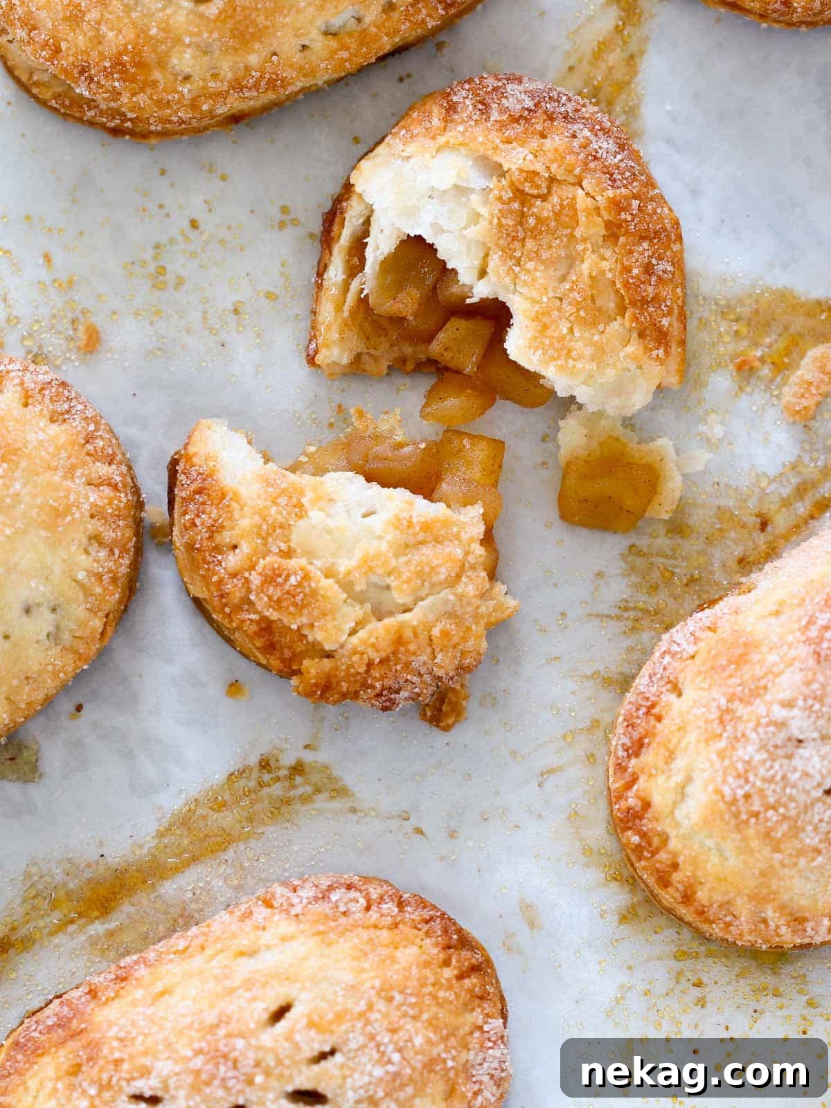 A perfectly baked apple hand pie, broken open to reveal a warm, spiced apple filling. Ideal for cozy fall gatherings.