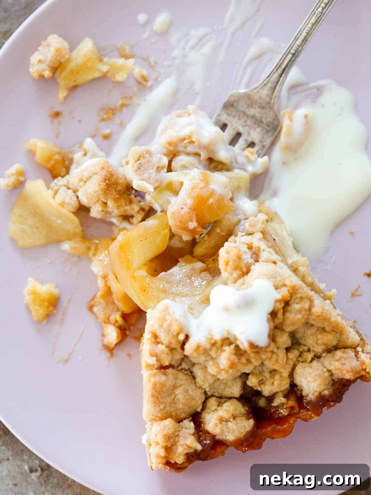 A luxurious caramel apple tart served with a side of crème anglaise, highlighting its rich layers and elegant presentation.