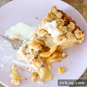 A close-up of a Caramel Apple Tart with a golden cinnamon streusel topping, showcasing its inviting textures.