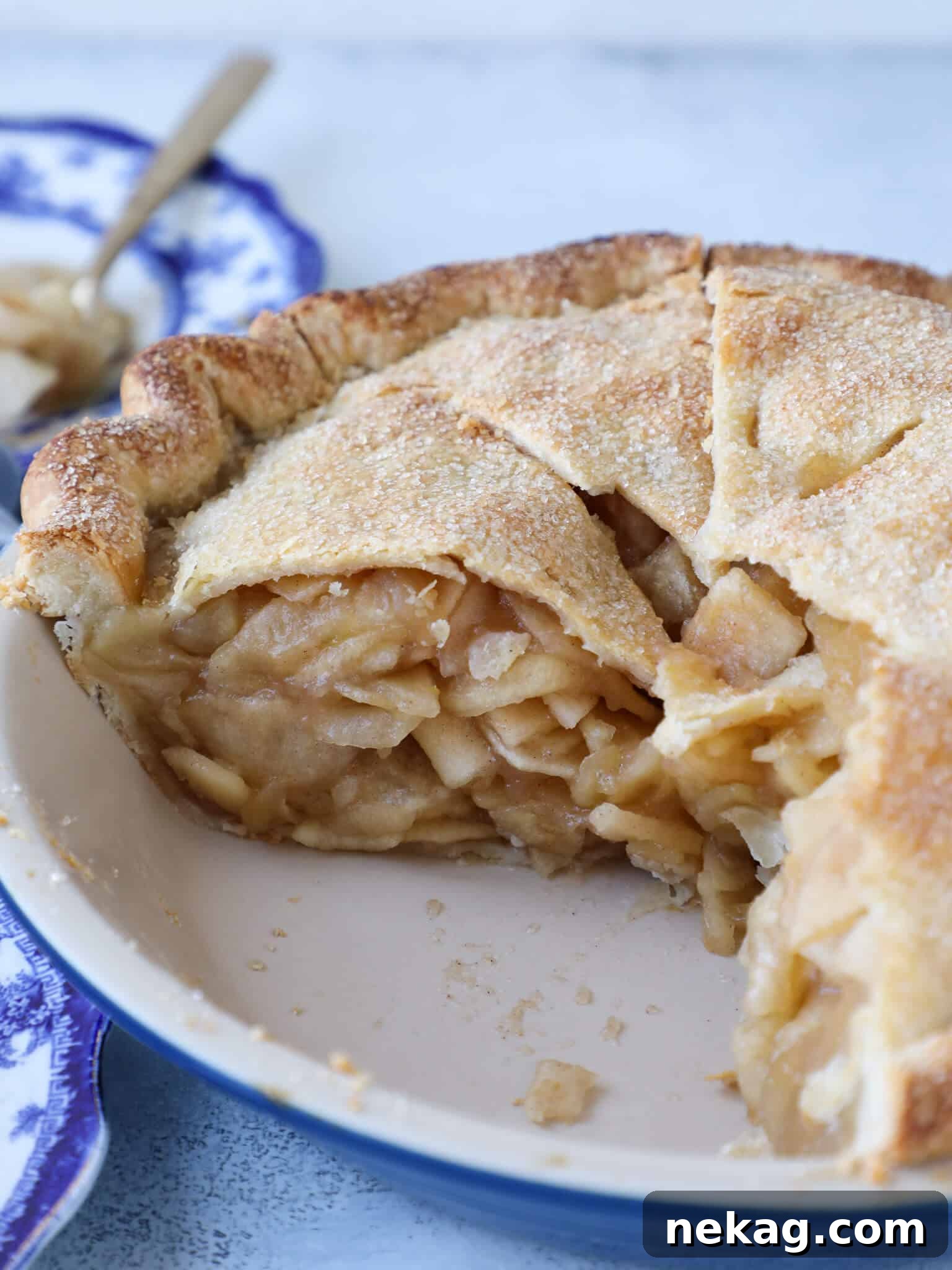 A towering Mile High Apple Pie, sliced to reveal its abundant, perfectly stacked apple filling and golden crust.