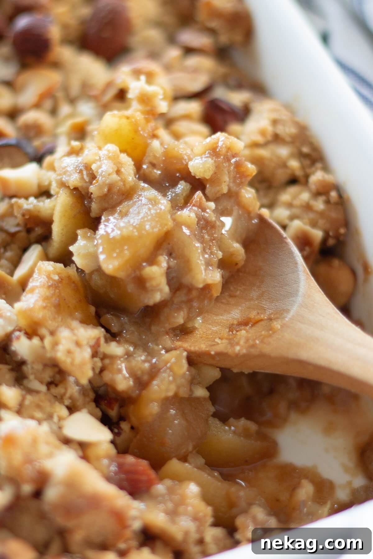 A spoonful of ginger spiced apple crumble, showcasing its warm, crumbly texture.