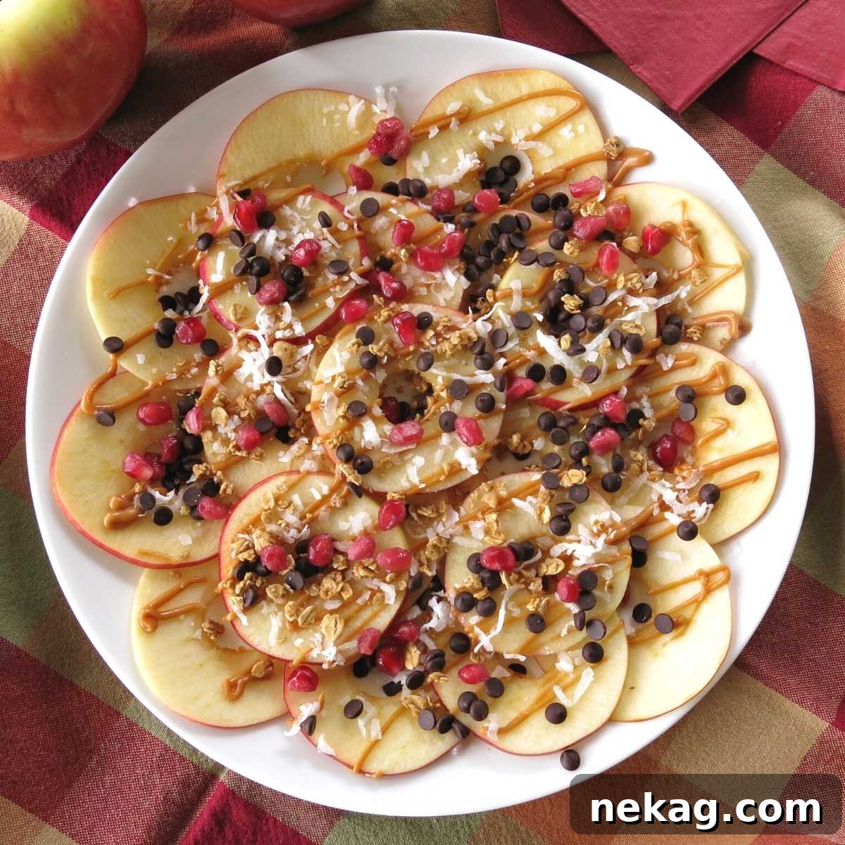 A vibrant platter of sliced apples generously drizzled with caramel sauce and various delightful toppings, resembling nachos.