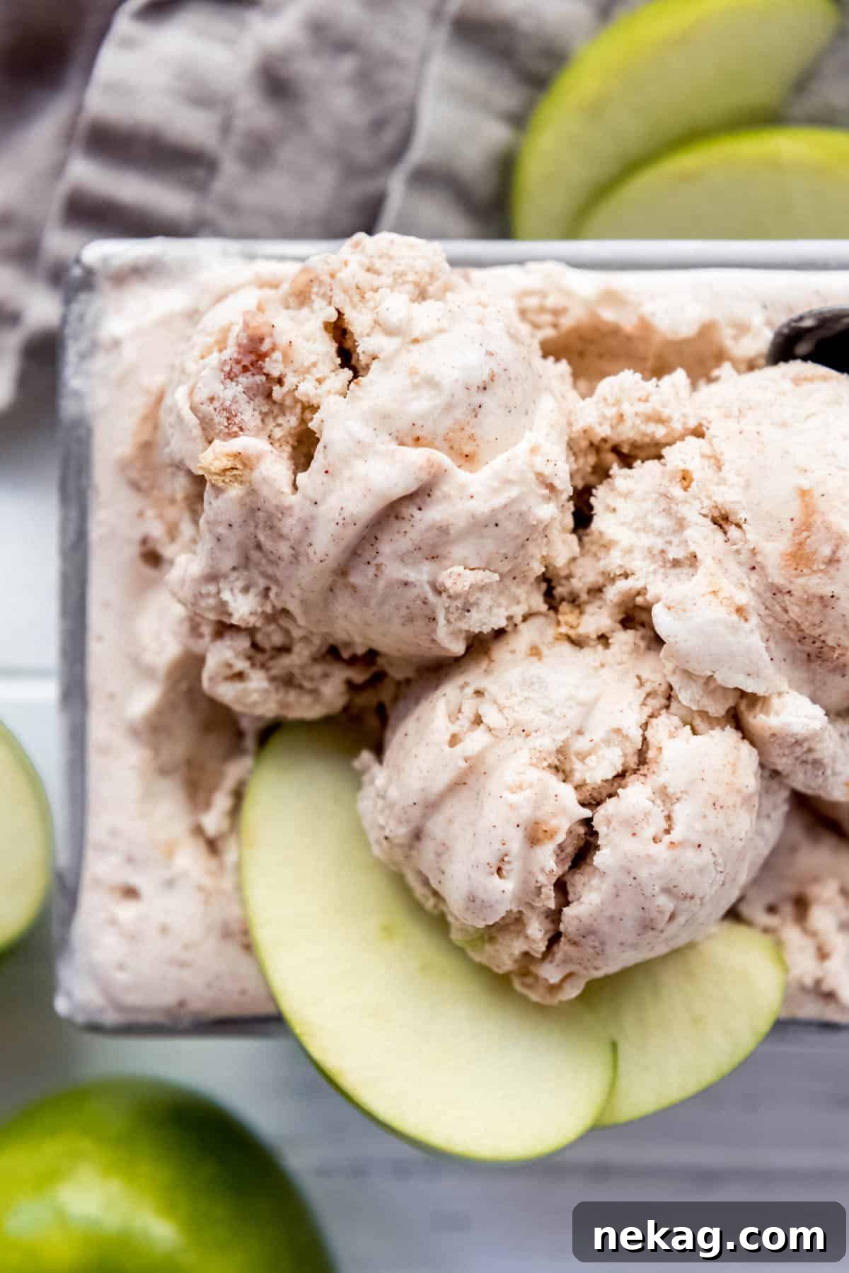 Creamy apple spiced ice cream, garnished with fresh apple slices, evoking the cozy flavors of autumn.