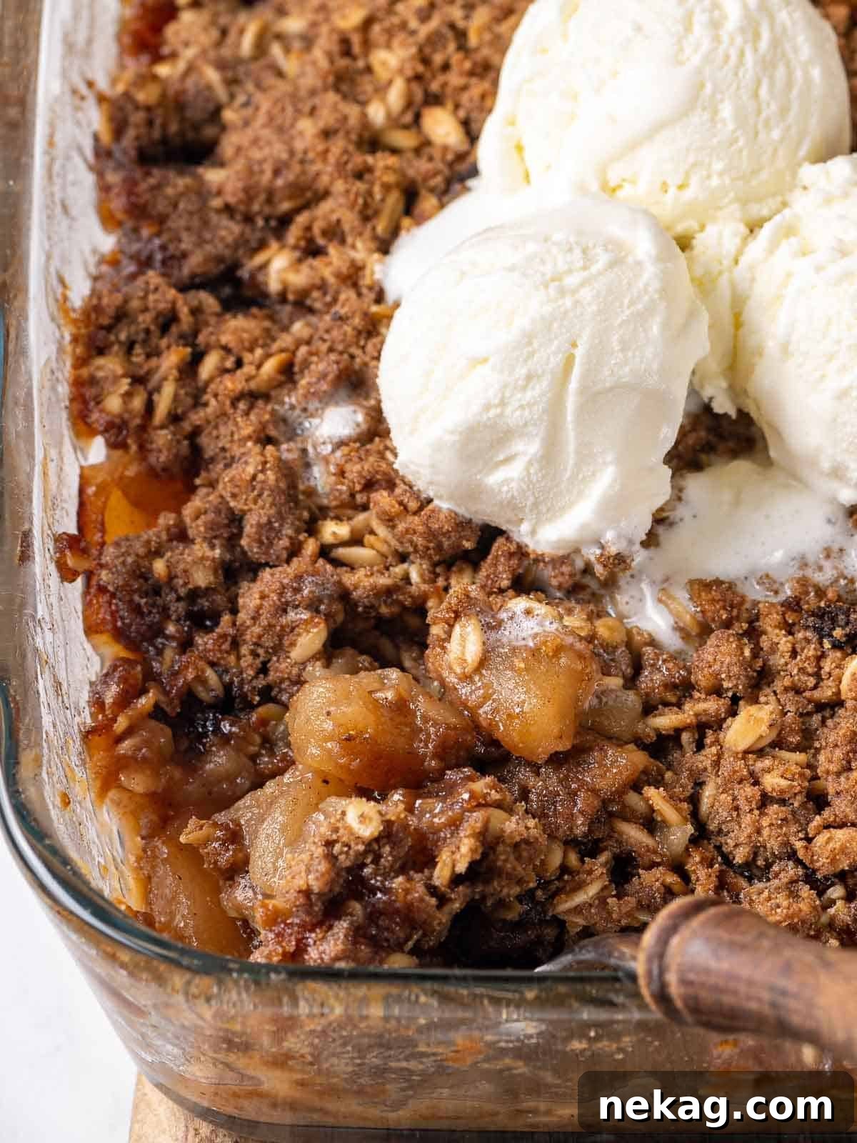 Effortless Golden Apple Crisp 2 Golden brown apple crisp in a baking dish, generously topped with melting vanilla ice cream.